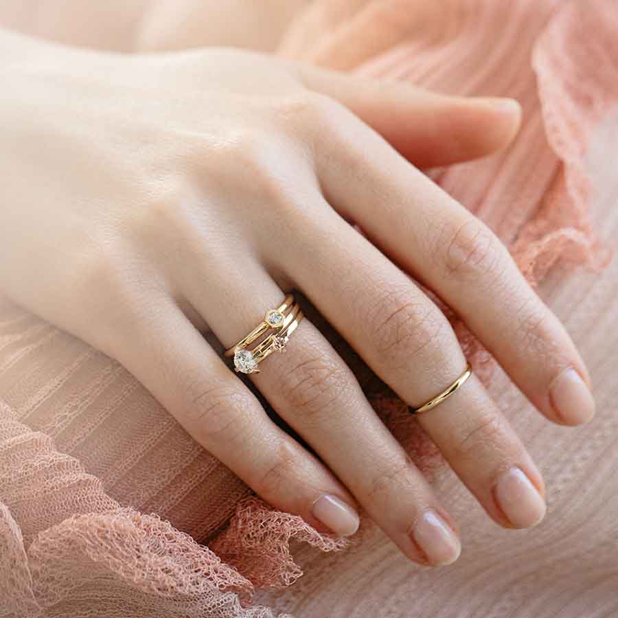 Model trägt mini Solitaire Ring aus recyceltem Gold